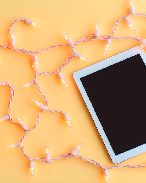 3D rendering of tablet device and light bulb, isolated on blue background.