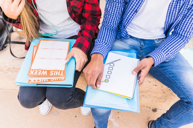 A close-up of a Spanish student studying with an educational guide, highlighting the guide's clear and concise explanations, diagrams, and practice questions.