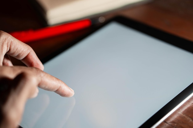 A close-up of a person's hands using a tablet to access an interactive educational guide. The screen displays colorful icons and a user-friendly interface, emphasizing the accessibility and engagement of digital learning resources. The person is focused and actively interacting with the content.