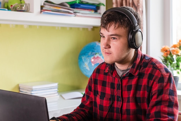 A student wearing headphones sitting at a desk, focusing on a computer screen displaying an interactive educational program. The setting is calm and conducive to studying, highlighting the personalized learning experience. The screen shows adaptive learning modules and progress tracking metrics.