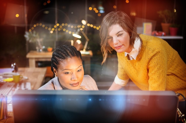 A teacher interacting with a student in a one-on-one setting, both looking at a digital learning platform on a tablet. The teacher is pointing to the screen, guiding the student through a personalized exercise.
