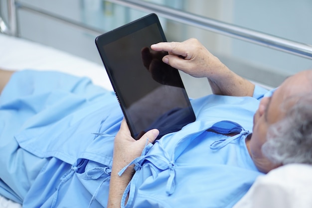 Close-up of a doctor using a tablet to monitor a patient's vital signs remotely, showcasing the use of 5G technology in telemedicine.