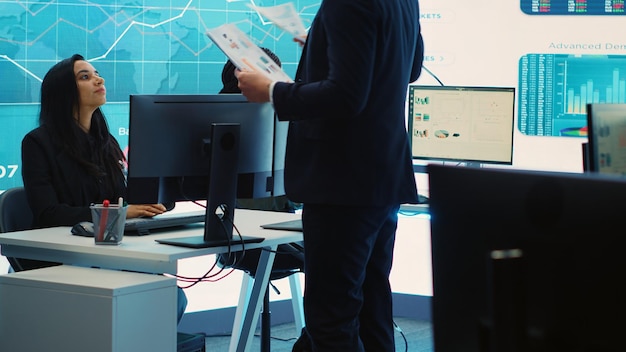 A team of IT professionals monitoring a cybersecurity dashboard, with charts and graphs displaying network activity and potential threats. Focus on collaboration and vigilance in defending against cyberattacks.