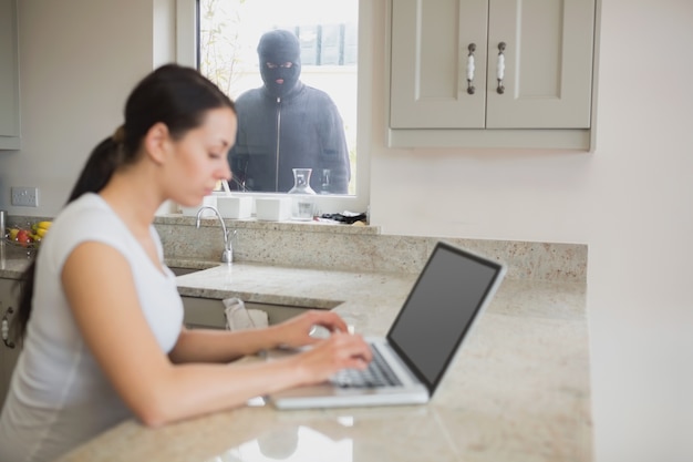A person sitting at a desk in their home in front of a computer using a computer to access the Seguridad Social website and filling out documents for the Ingreso Mínimo Vital.