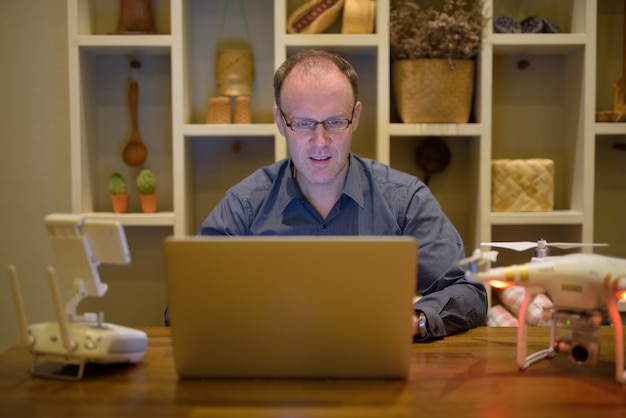 A person sitting at a desk with a laptop, looking at a website with information about the Bono Social Eléctrico. The person is smiling and appears to be understanding the information presented.