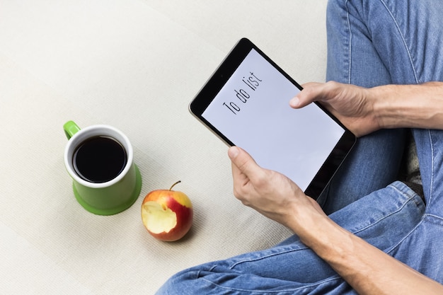 A close-up of hands filling out an online form on a tablet with the words 