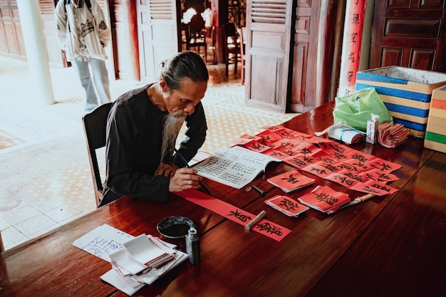 A Vietnamese official reviewing a pile of documents related to work visa applications in a government office.
