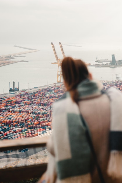 A close-up shot of a cargo ship being loaded with shipping containers at a port in China, with workers and cranes in the background.