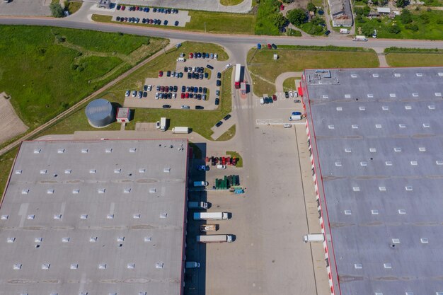 An aerial view of a modern warehouse with trucks loading and unloading goods, showcasing efficient logistics operations.