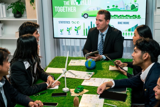 A meeting room with executives from Spanish and Indonesian companies discussing investment opportunities, with charts and graphs showing projected growth in renewable energy sectors.