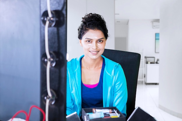 A high-tech Indian hospital ward with advanced medical equipment, with a focus on telemedicine and remote patient monitoring. A Spanish doctor is giving a video consultation to an Indian patient, with the hospital logo subtly visible in the background.