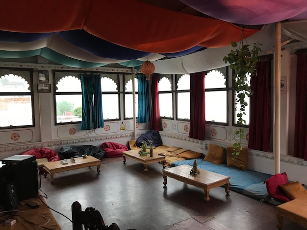 A meeting room in India, decorated with traditional Indian art, with a diverse group of Spanish and Indian businesspeople negotiating a deal. They are discussing contracts and documents related to healthcare.
