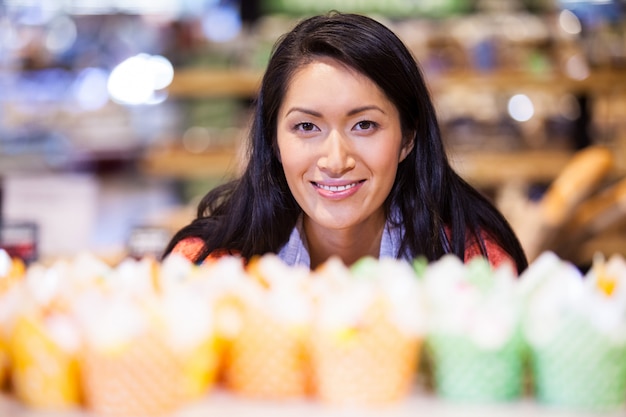 A Vietnamese family in a modern supermarket, examining Spanish olive oil and canned goods, with other imported products visible in the background. Focus on the consumer interest and product placement.