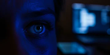 Strained eyes reflecting blue light from digital screens, symbolizing the impact of screen time on eyesight.